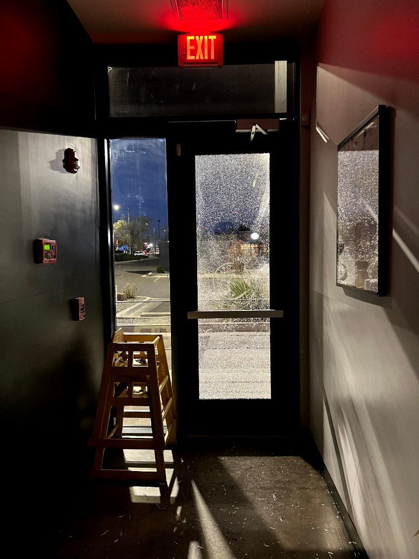 A hallway with a red exit sign above the door.