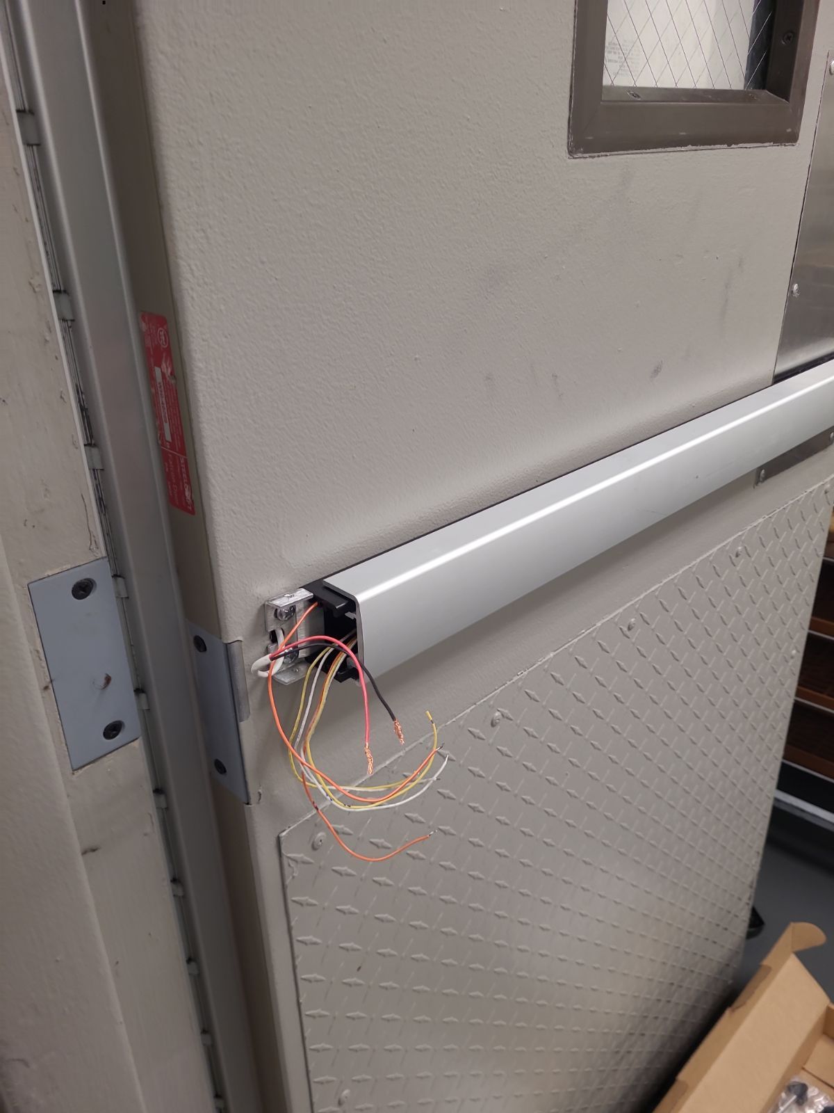 A close up of a door with wires coming out of it.