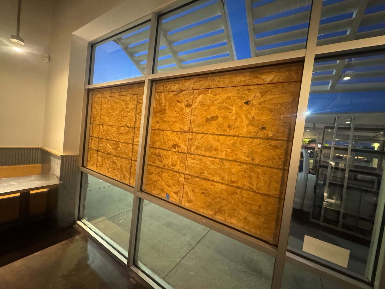 A building with a lot of windows covered in plywood.