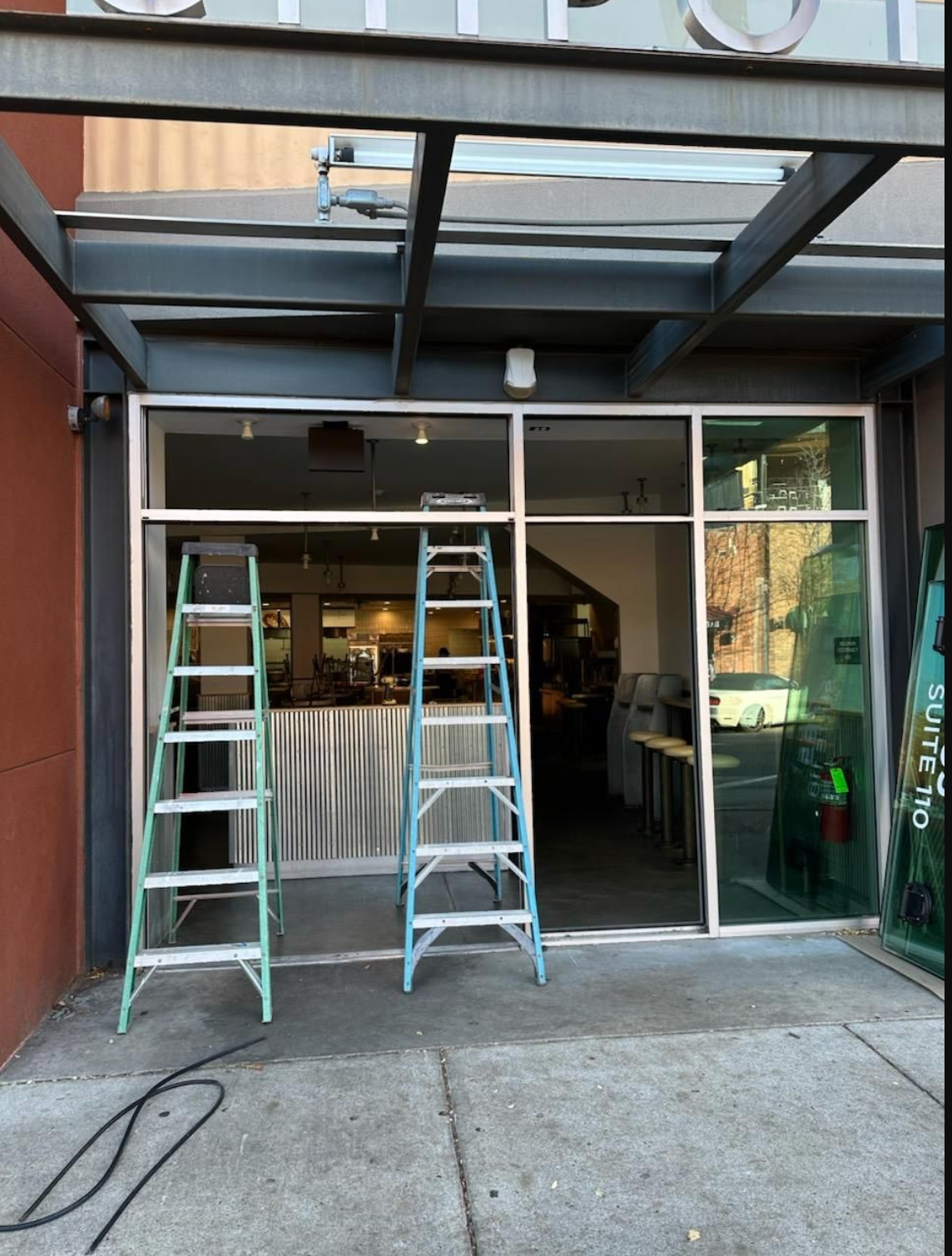 Two ladders are sitting outside of a building