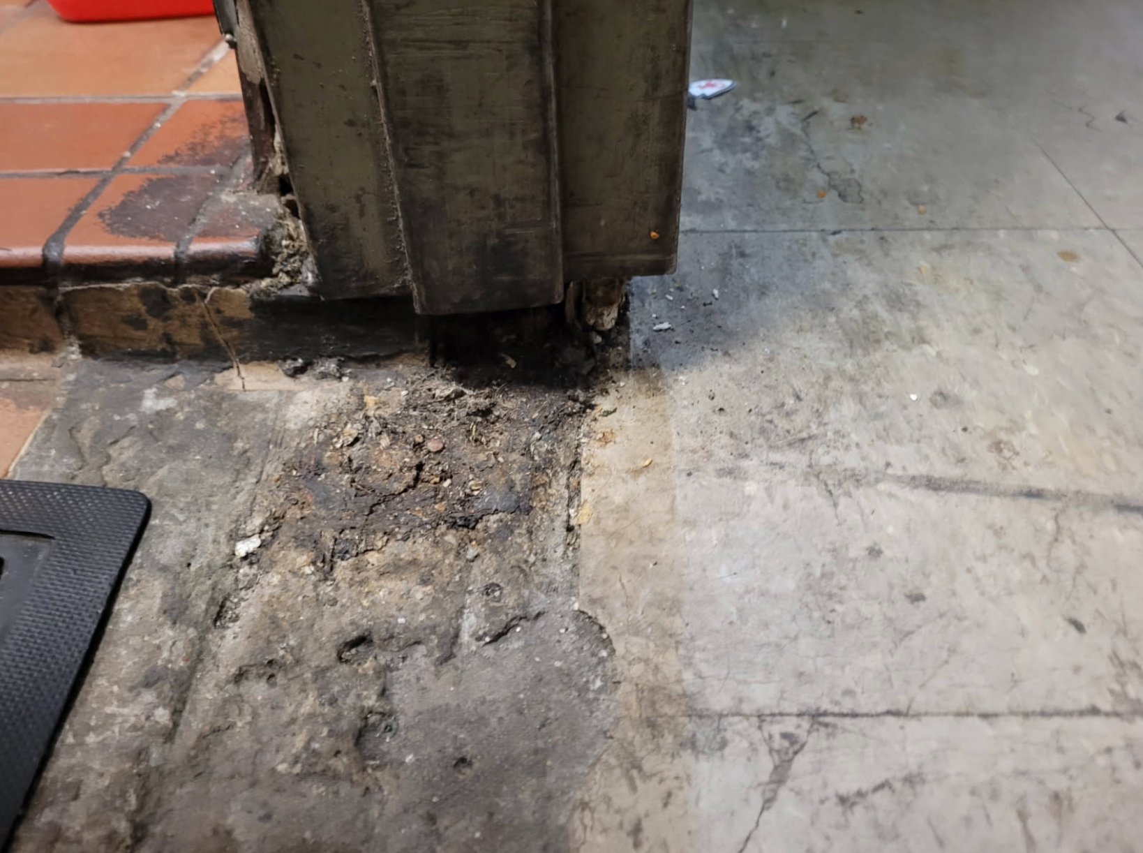 A close up of a dirty floor with a door in the background.