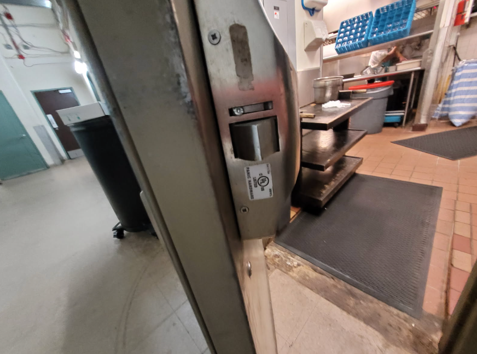 A door with a lock on it is open to a kitchen.