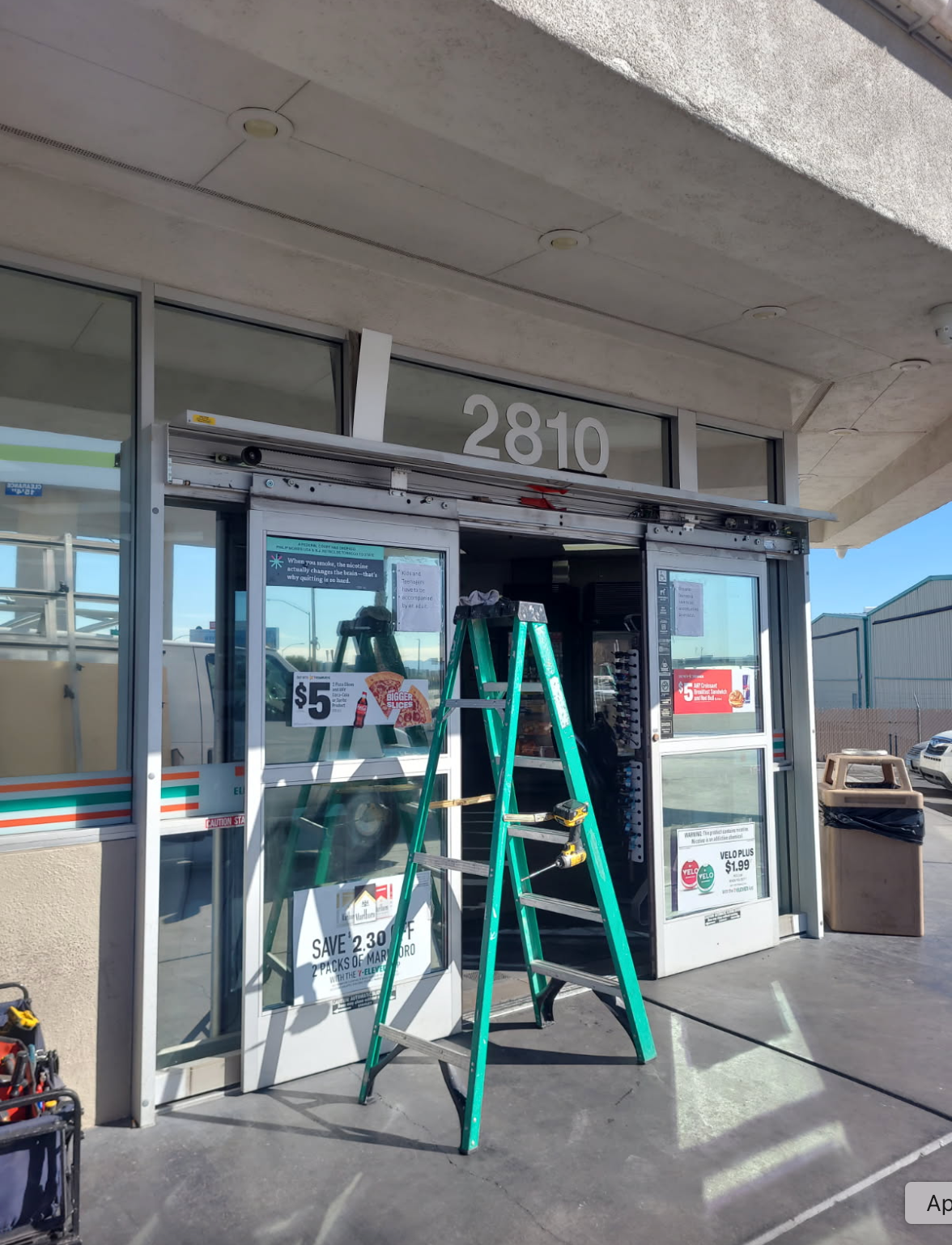 A ladder is sitting in front of a store with the number 2810 on it