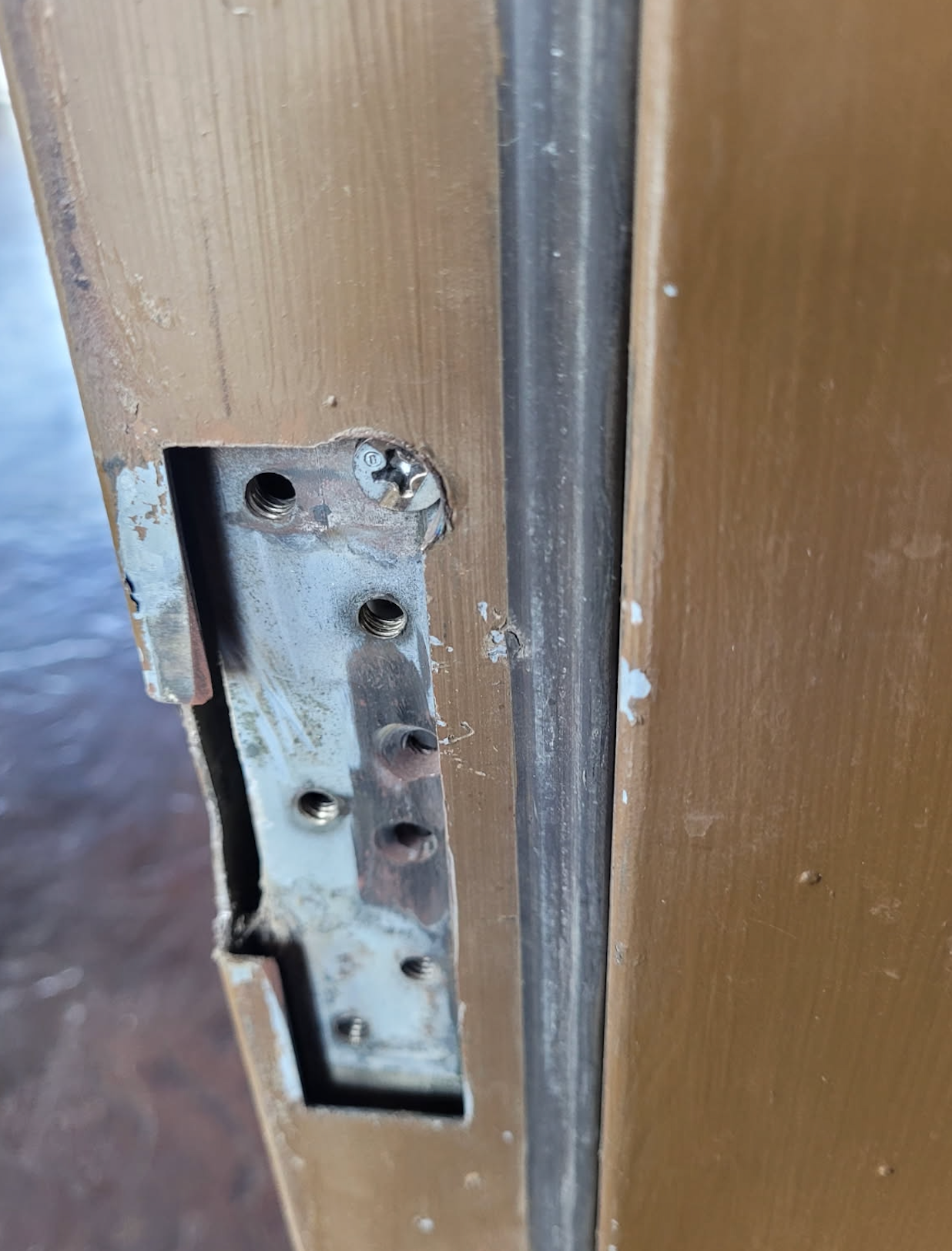 A close up of a door lock on a wooden door.