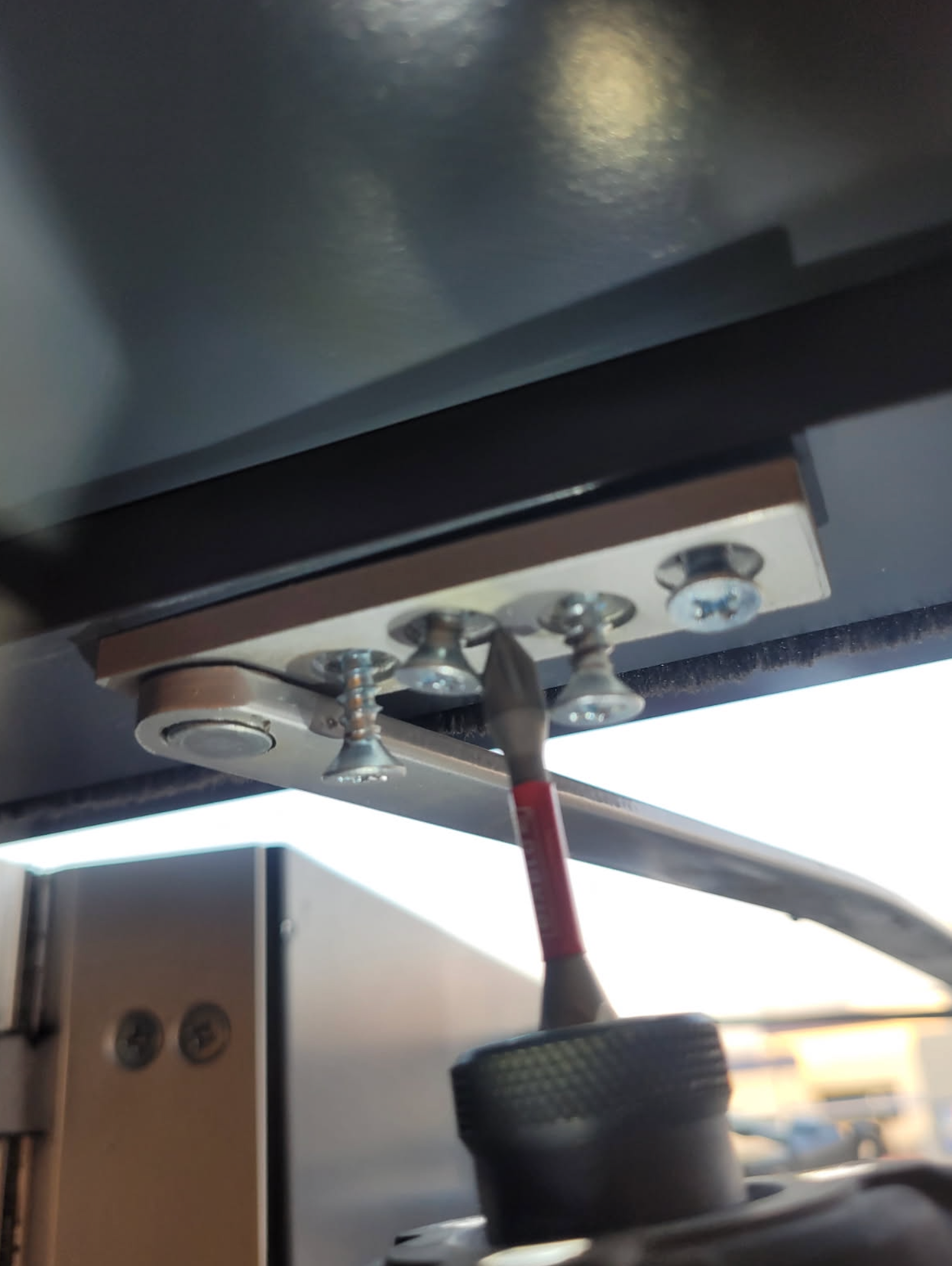 A person is using a screwdriver to fix a door