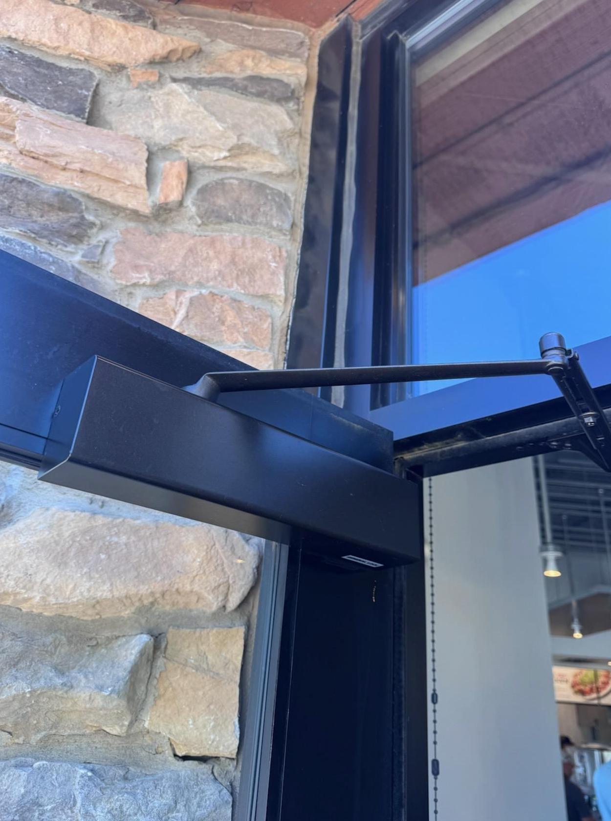 A close up of a door with a brick wall in the background.