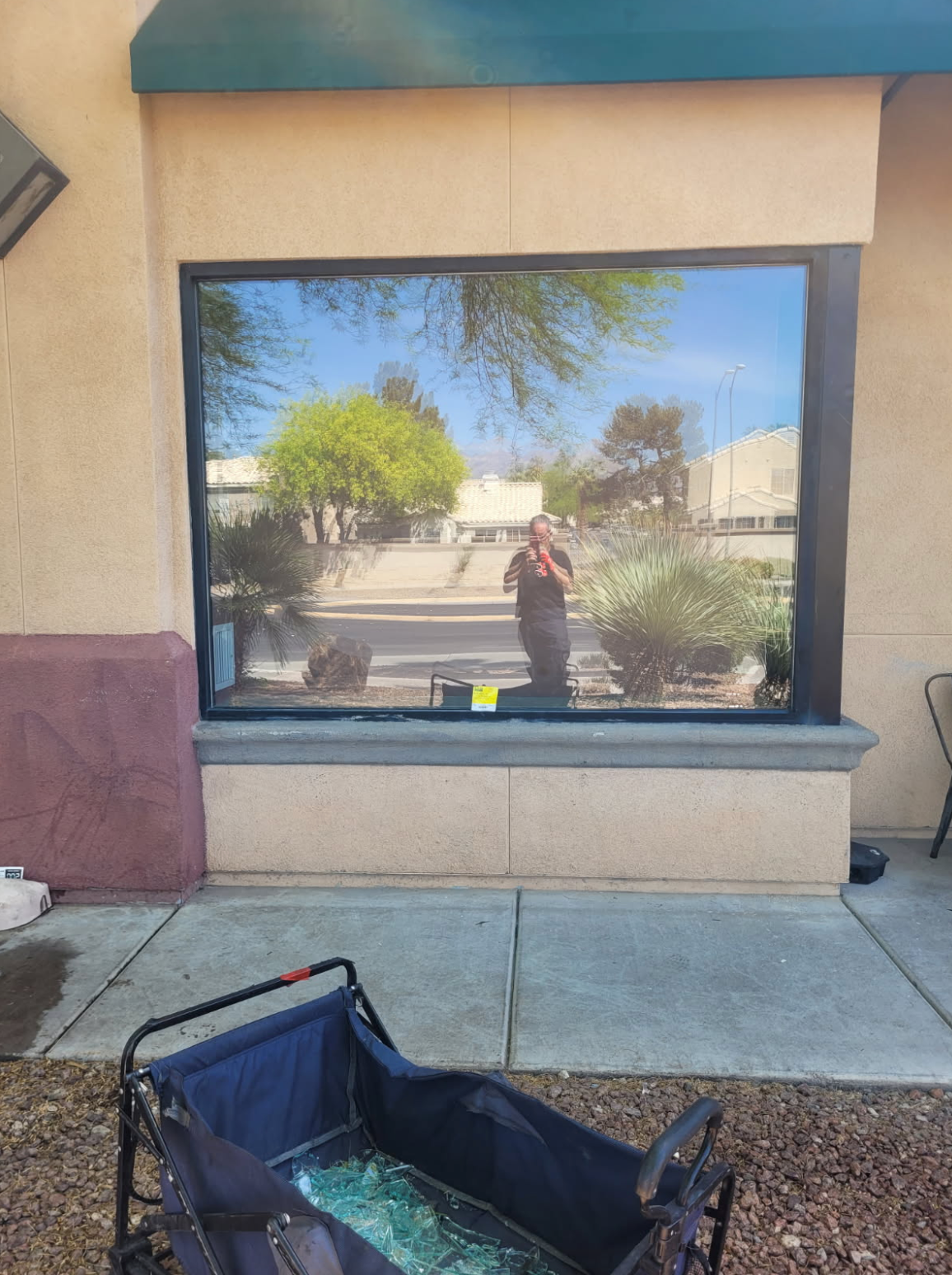 A stroller is parked in front of a large window.