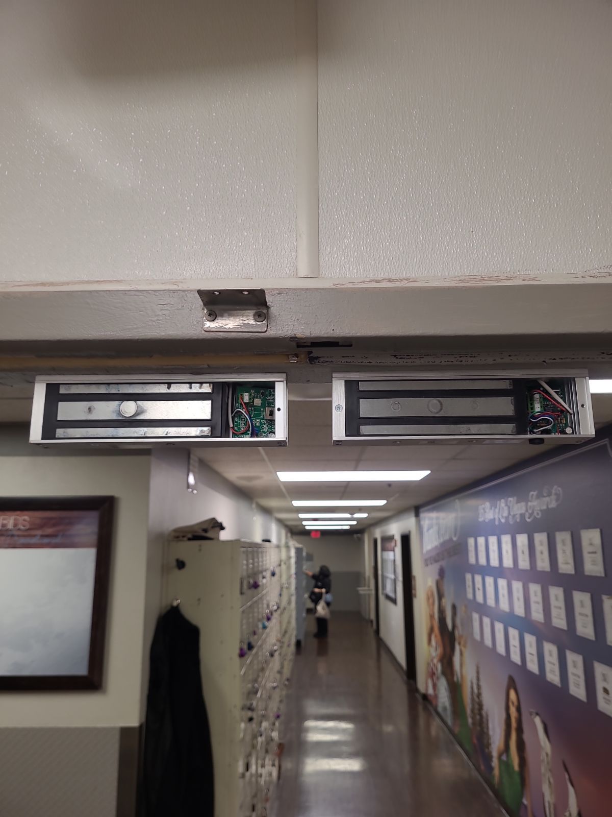 A long hallway with lockers and a sign on the wall.
