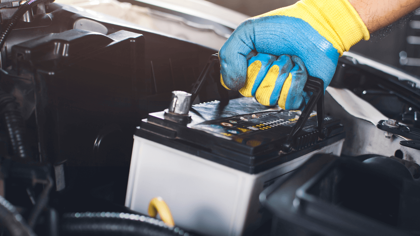 A mechanic swapping a battery in a car