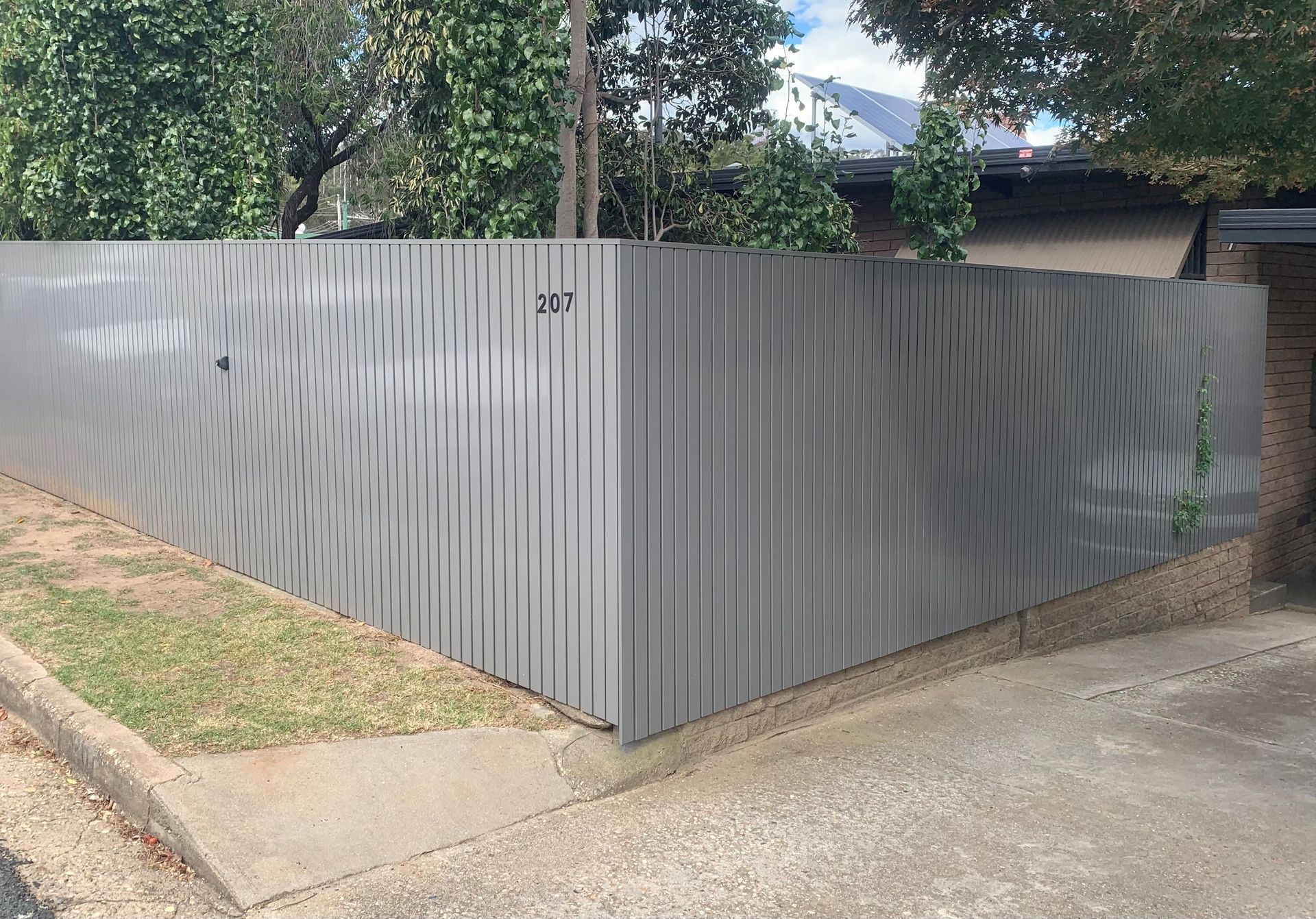 A black and white photo of a wooden fence with shadows on it.