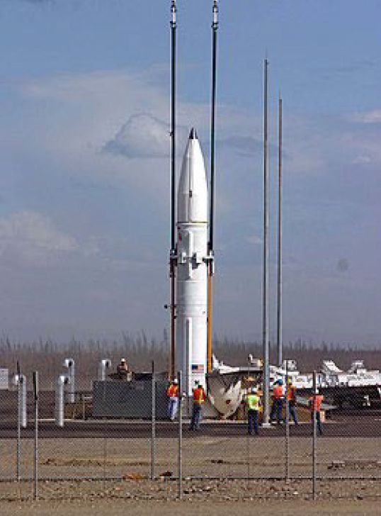 A rocket is being lifted into the air by a crane