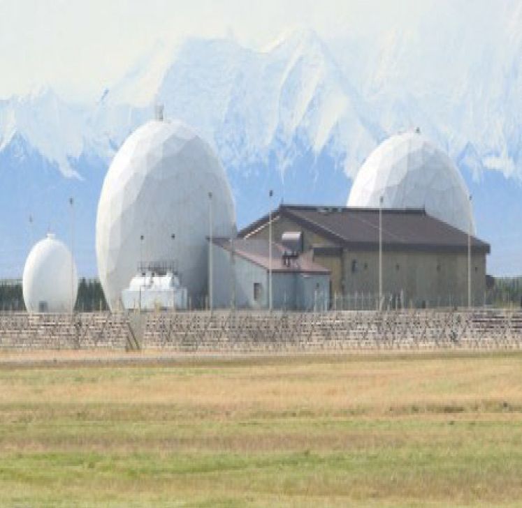 A large building with a lot of antennas in front of it