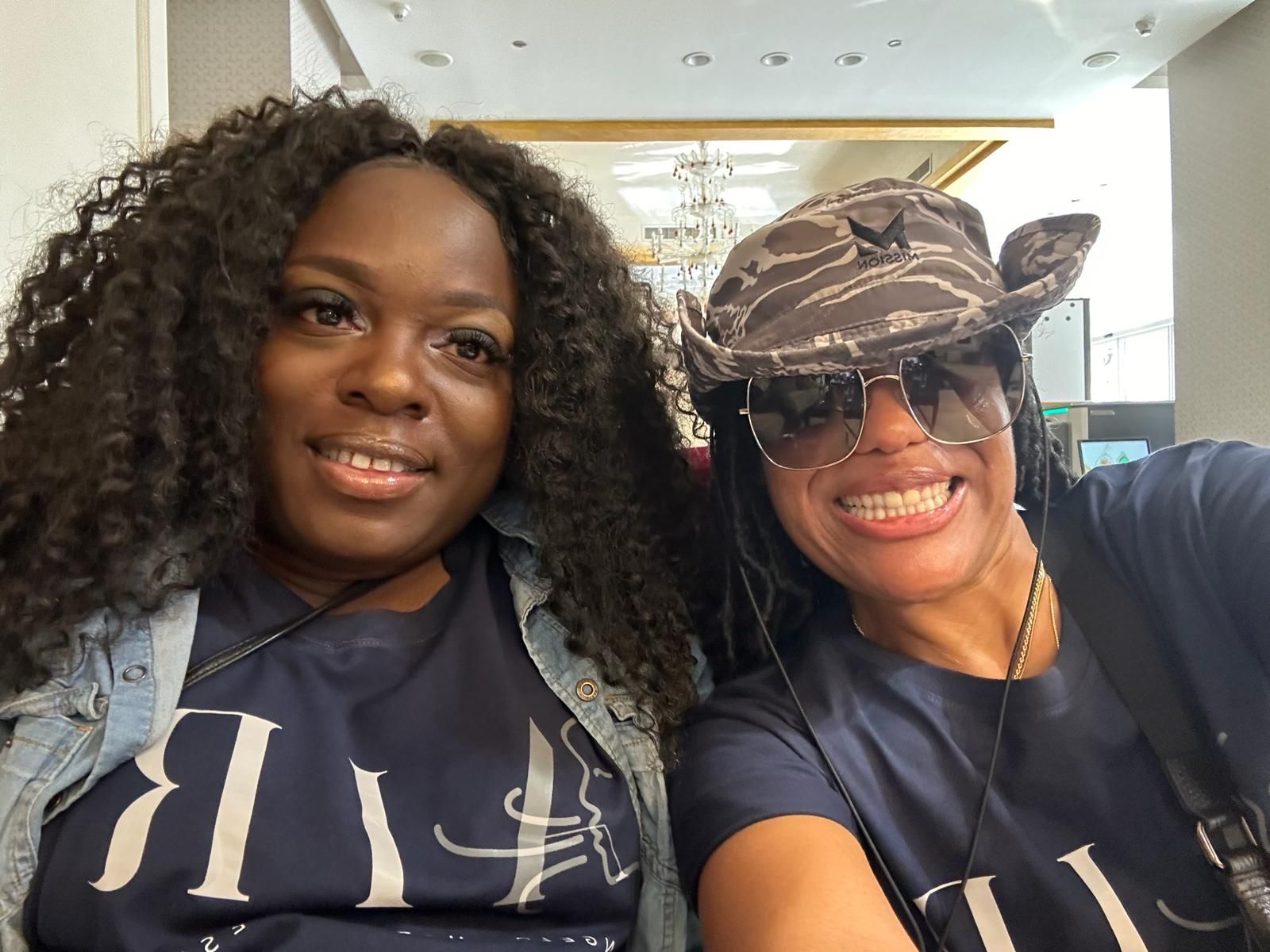 Two women are posing for a picture and one is wearing a cowboy hat