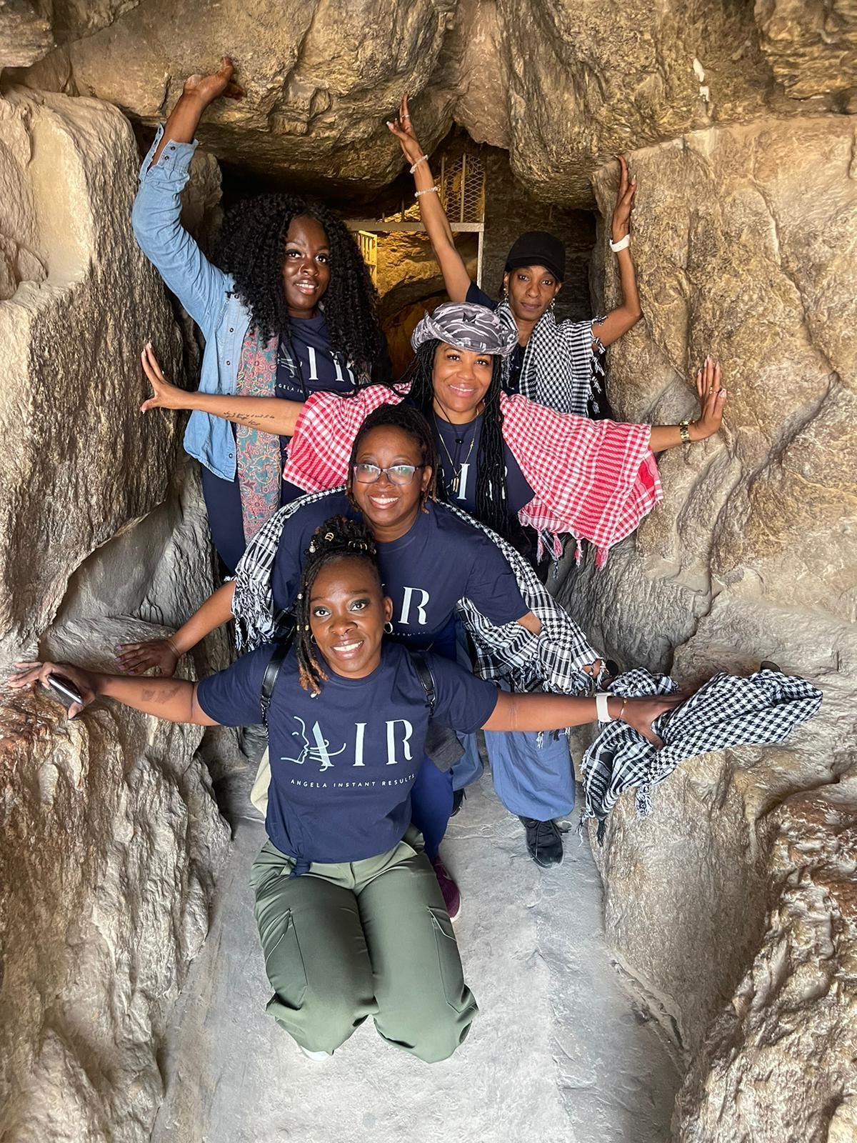 A group of young girls are posing for a picture in a cave.