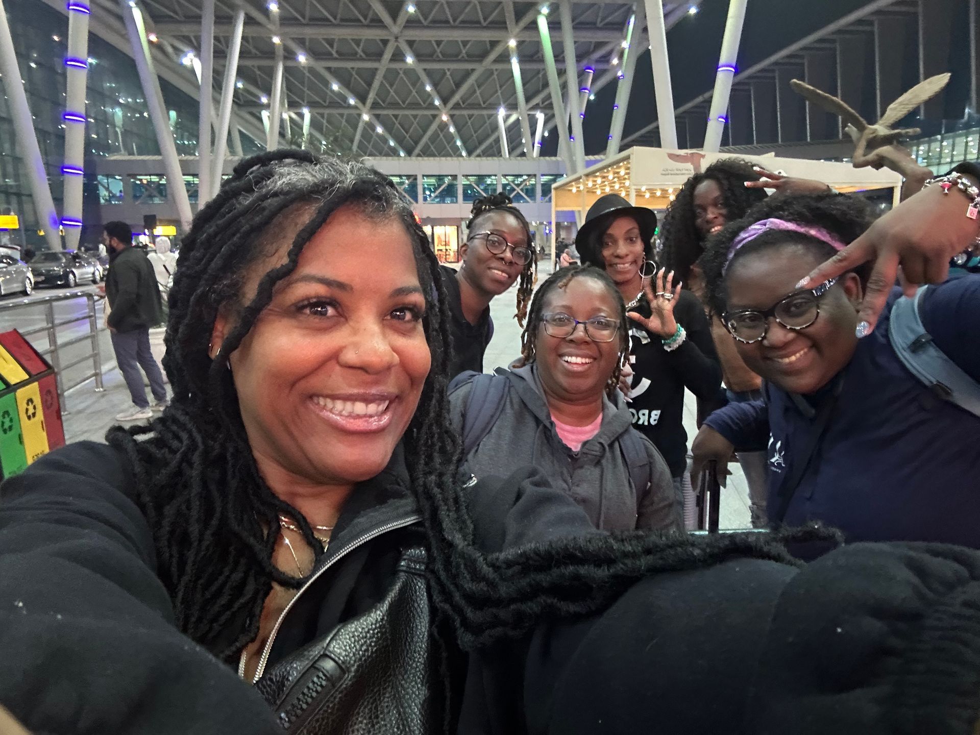 A group of people are posing for a picture at an airport.