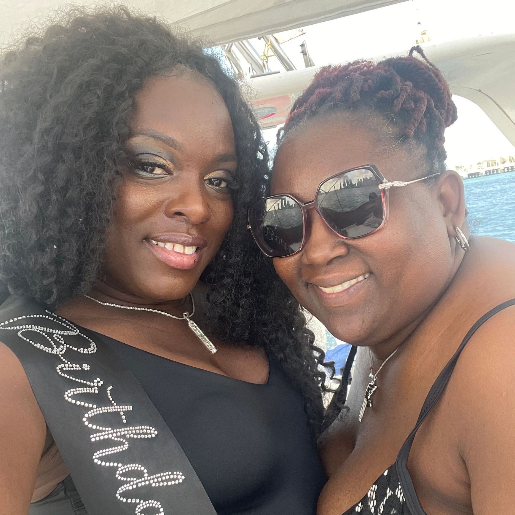Two women posing for a picture with one wearing a sash that says bachelorette
