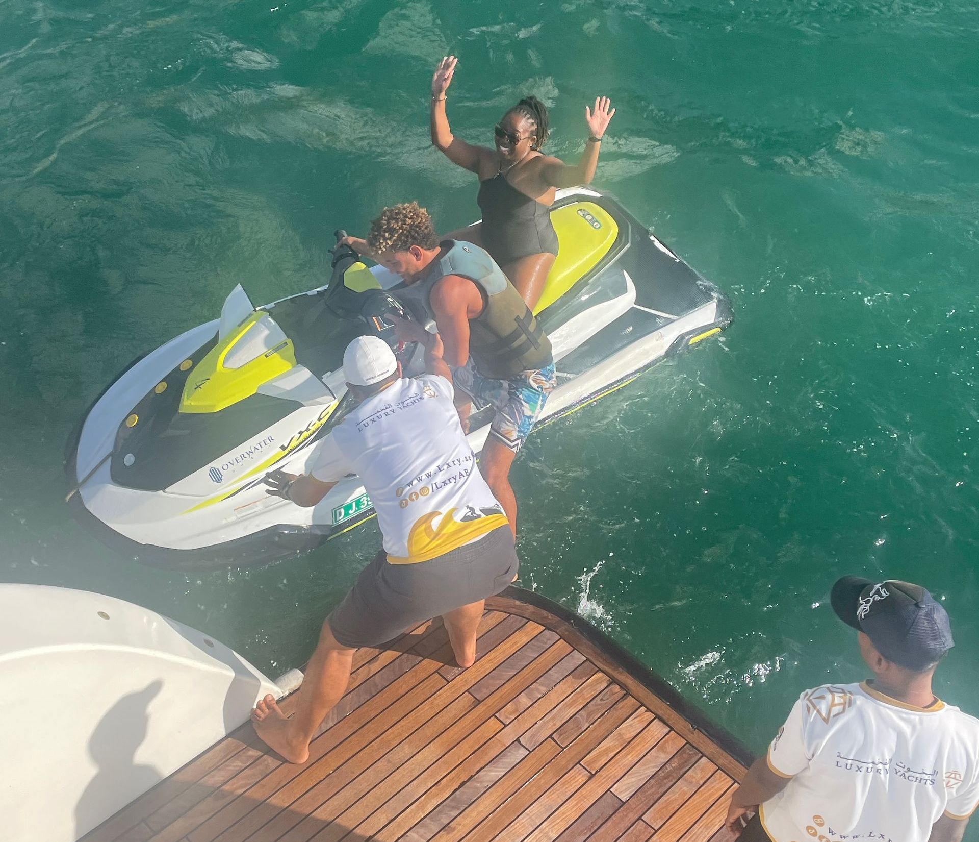A group of people are standing on a dock near a jet ski
