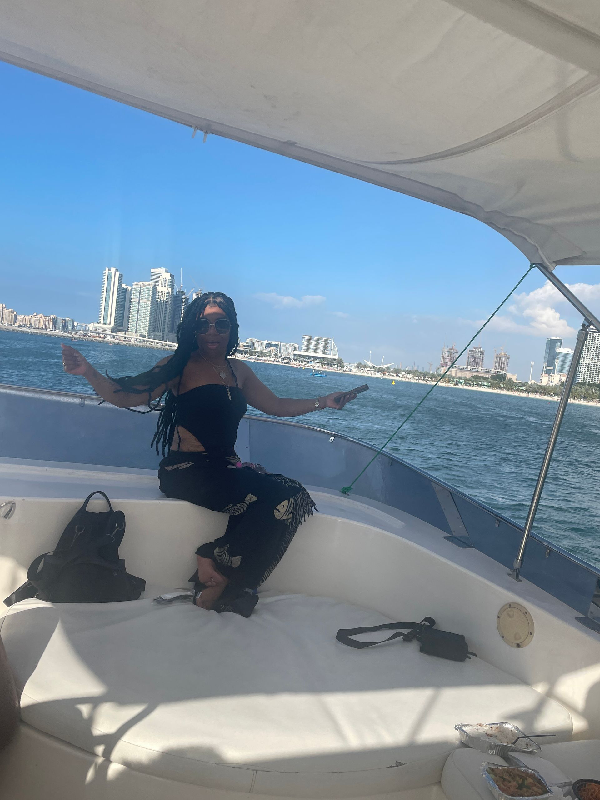 A woman is sitting on the side of a boat in the ocean.