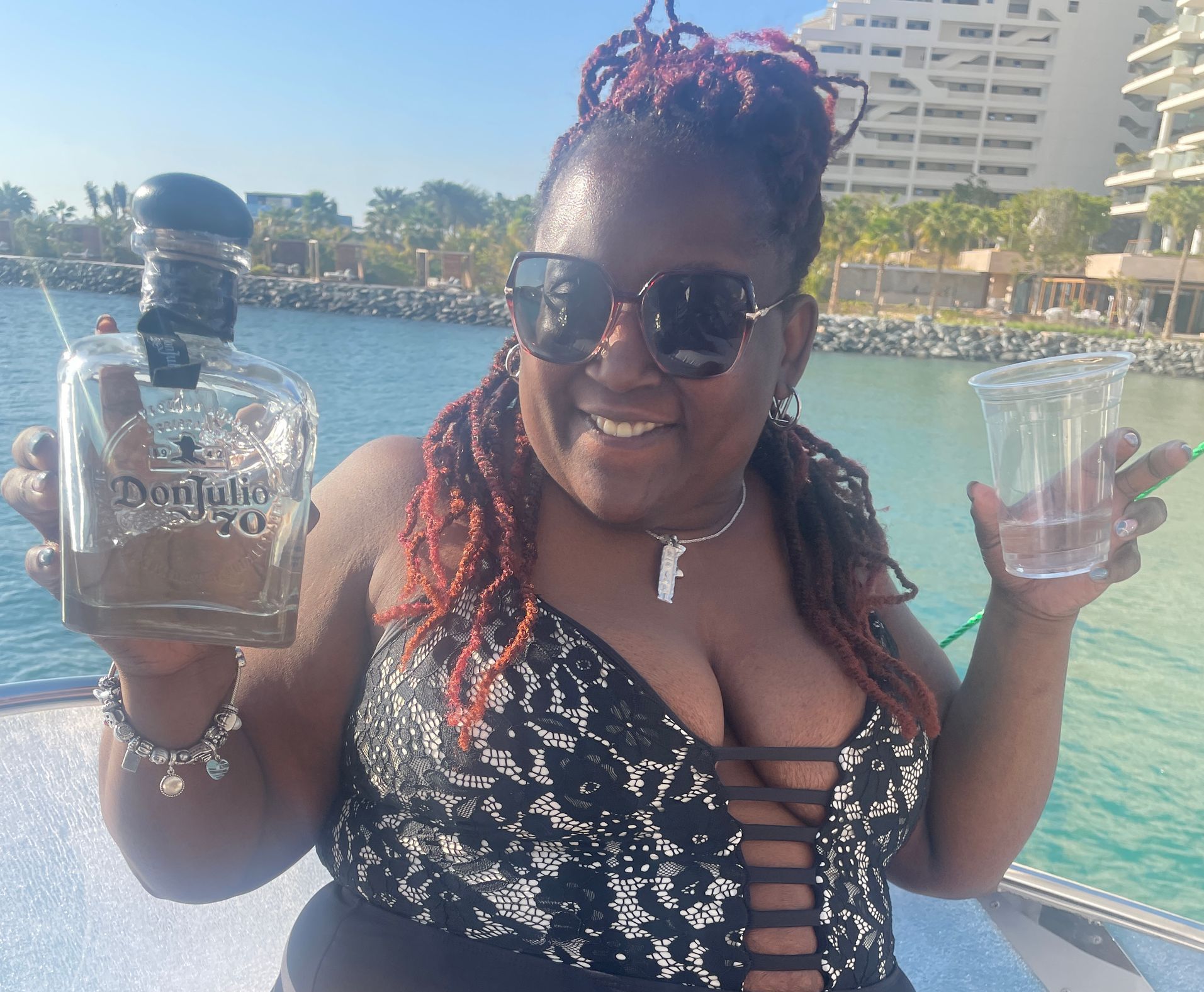 A woman holding a bottle of tequila and a cup