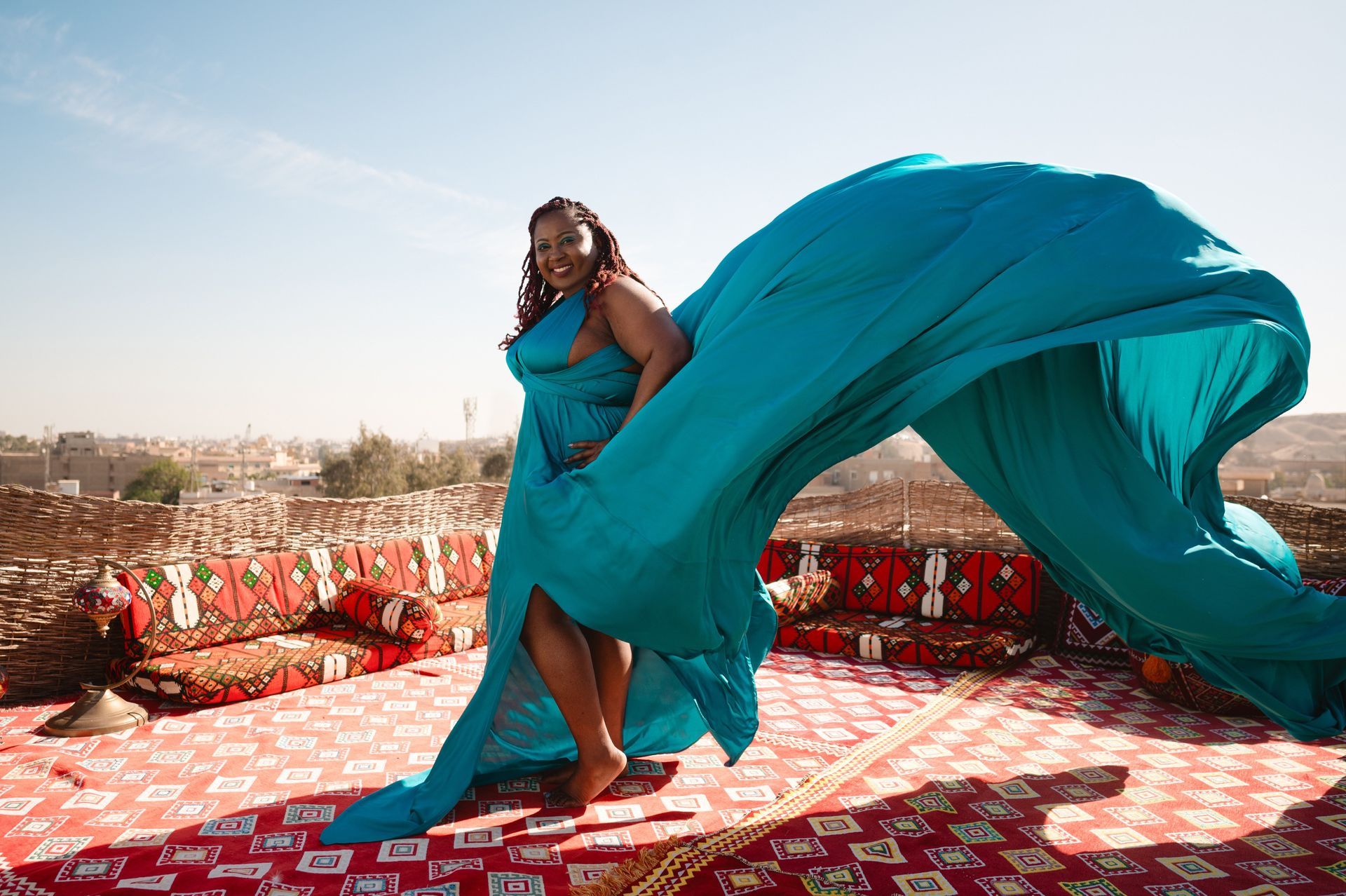 A woman in a blue dress is standing on a red rug.