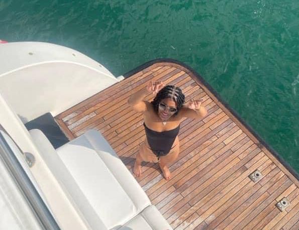 A woman in a bikini is standing on the deck of a boat.
