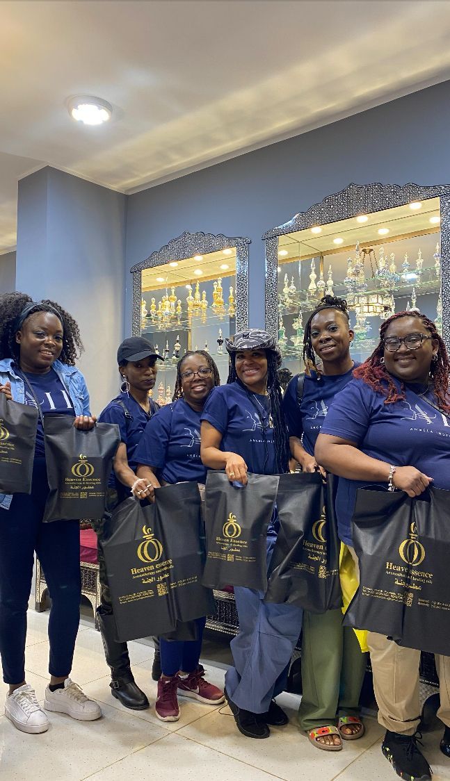 A group of women are standing next to each other in a room holding bags.