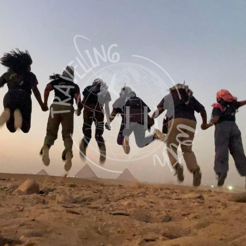 A group of people jumping in the air with the word travelling in the background