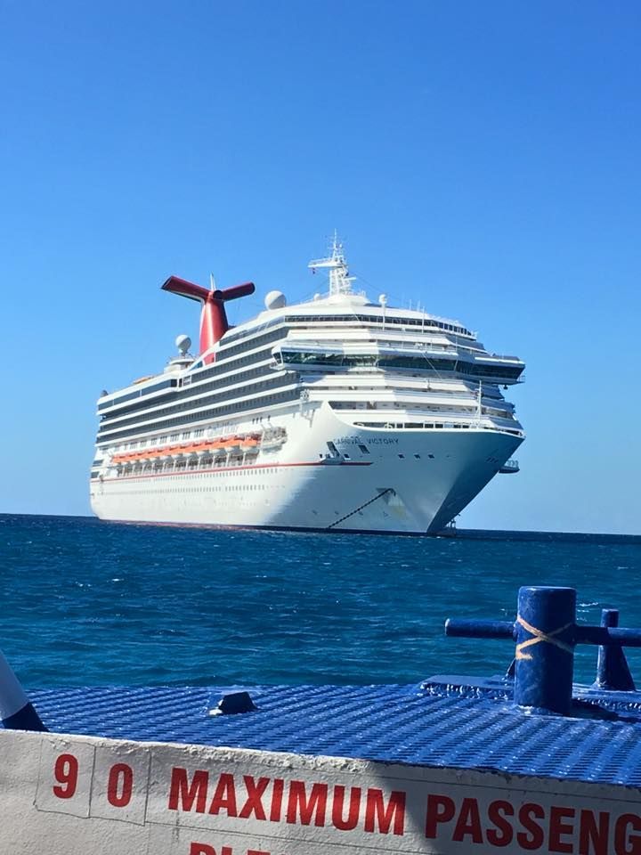 A large cruise ship is floating in the ocean next to a sign that says 90 maximum passeng