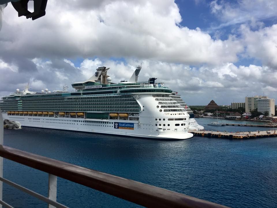 A large cruise ship is docked in a harbor