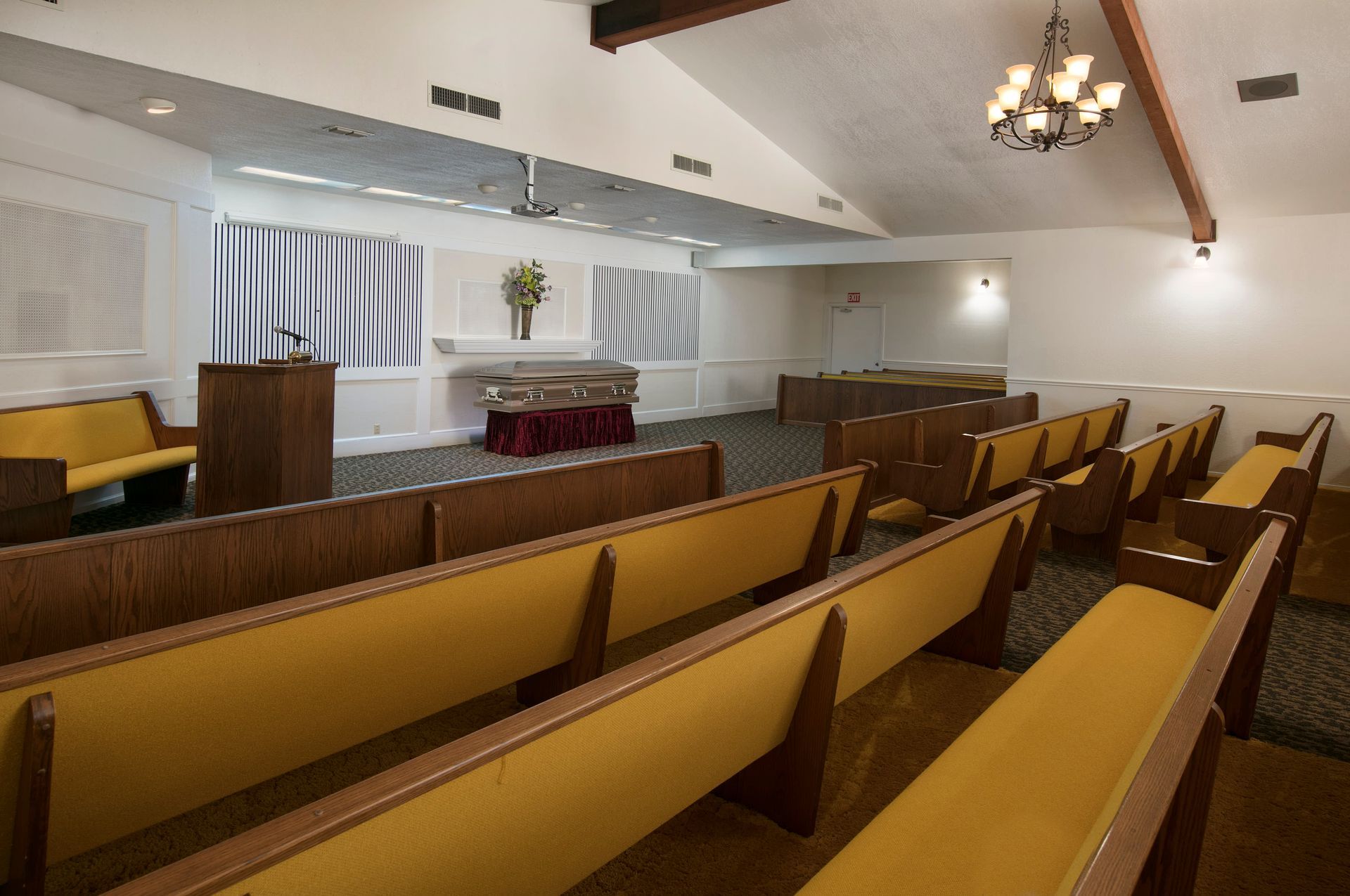 An empty church with yellow benches and a podium