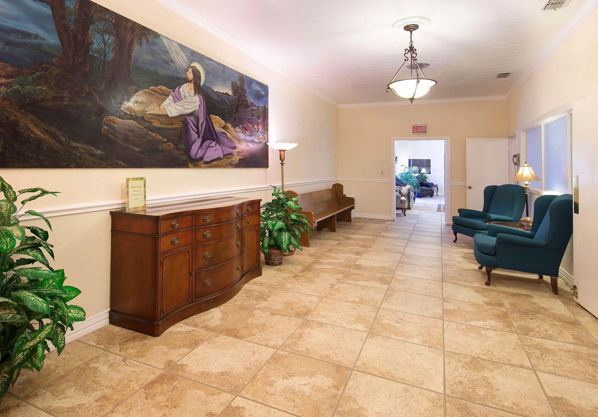 A long hallway with chairs and a painting on the wall.