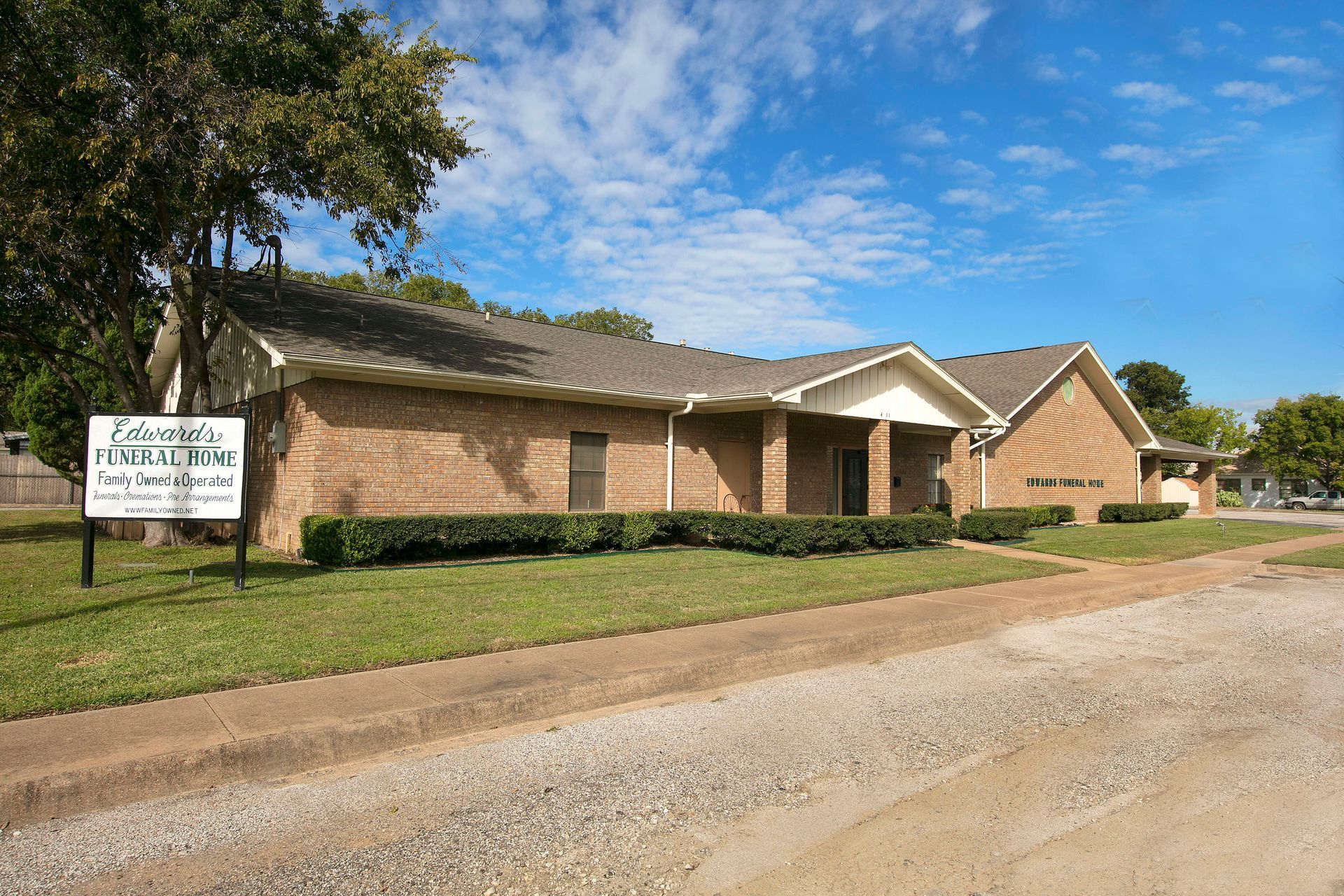 A large brick building with a sign in front of it