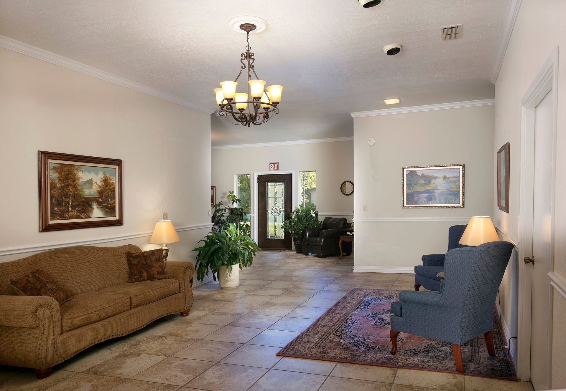 A living room with a couch and chairs and a chandelier