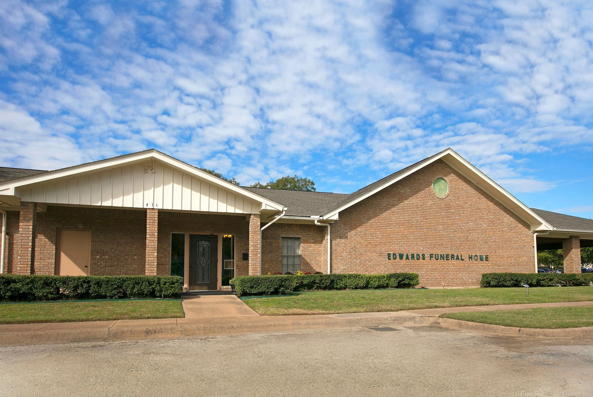 A brick building with a white roof and the word funeral home on it