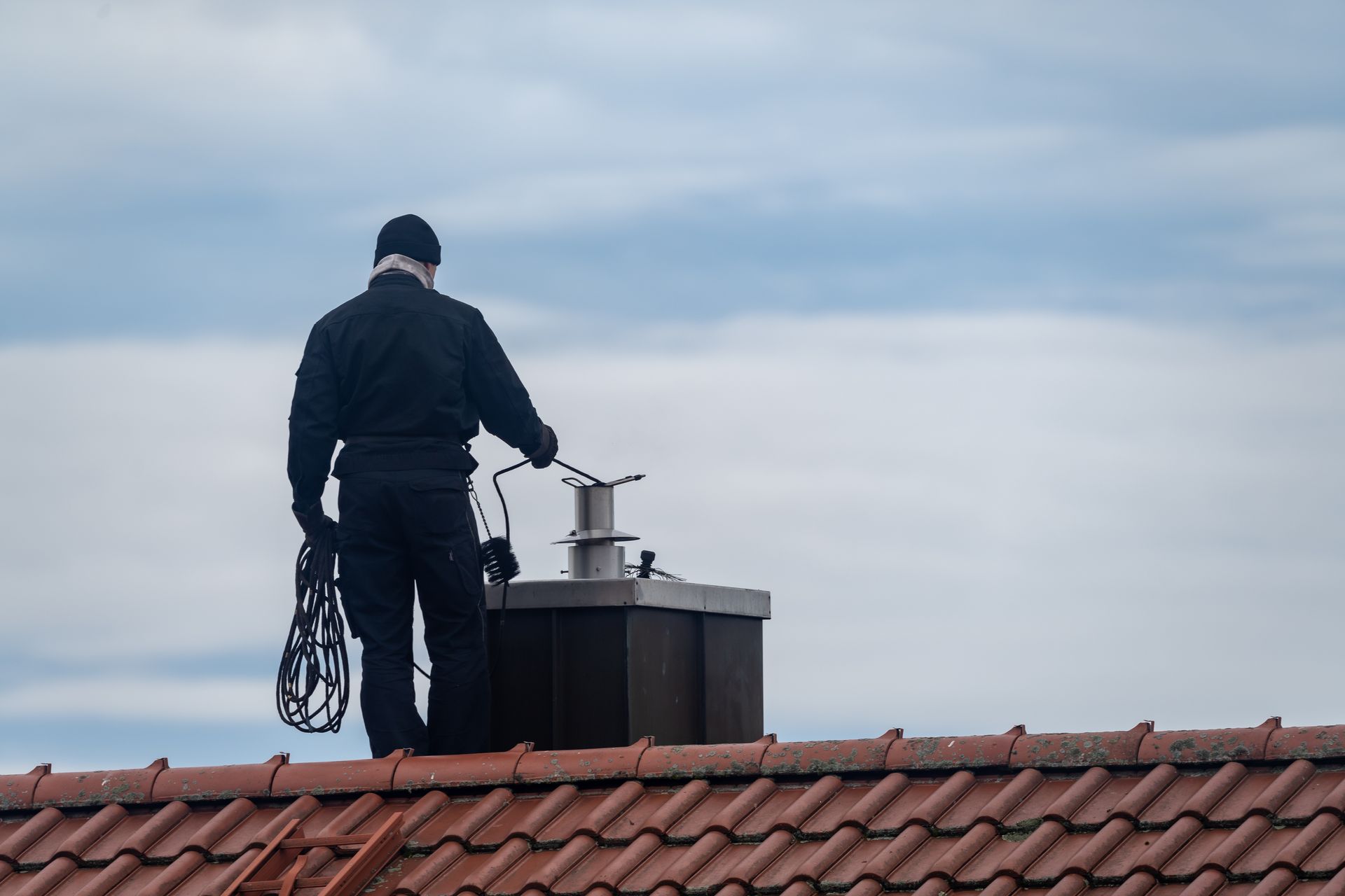 A man is cleaning a chimney. A man is cleaning a chimney.