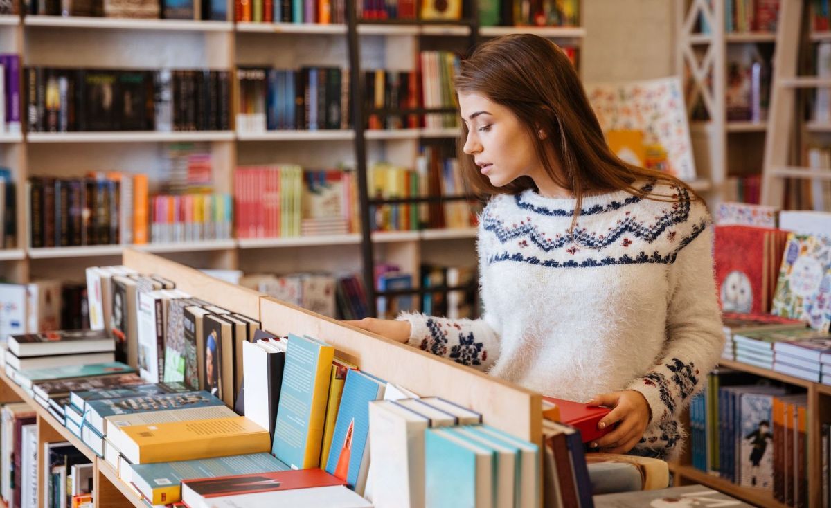 A woman is looking at books in a bookstore.