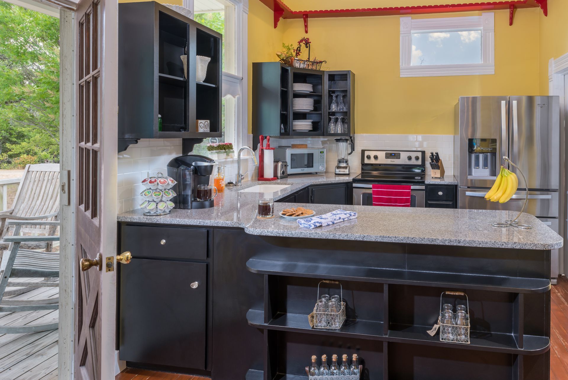 A kitchen with black cabinets and granite counter tops