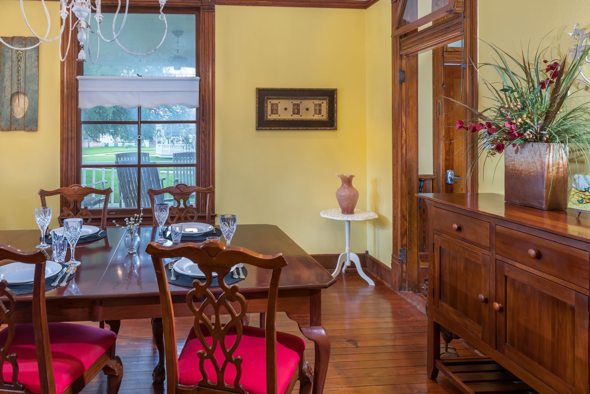 A dining room with a table and chairs and a dresser.