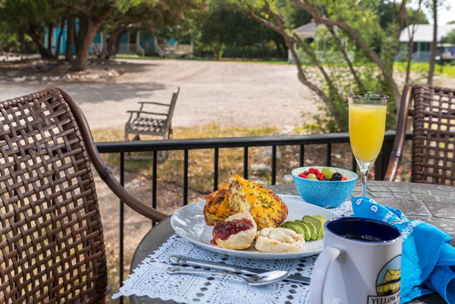 A table with a plate of food and a glass of orange juice on it.