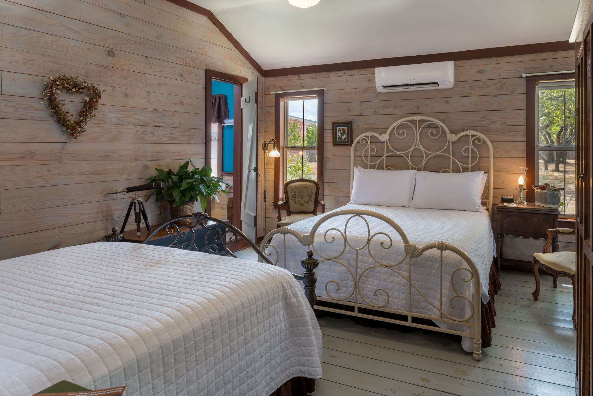 A bedroom with two beds and a heart on the wall.