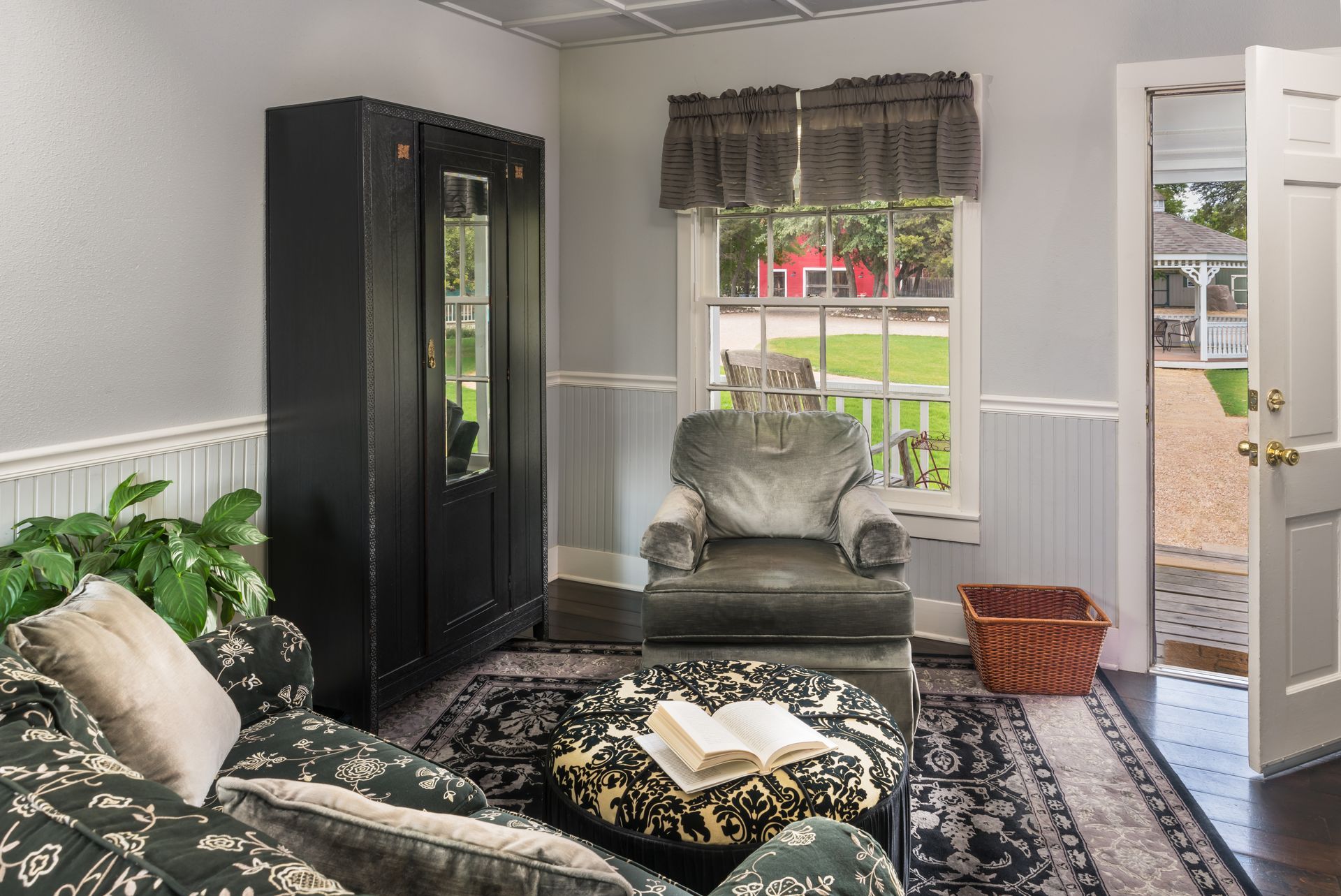 There is a book on the ottoman in the living room.