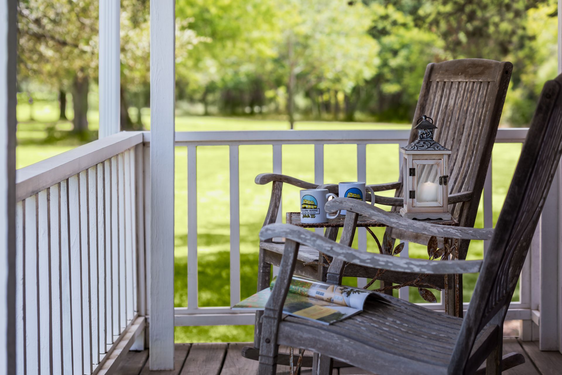 There is a rocking chair on the porch with a magazine on it.