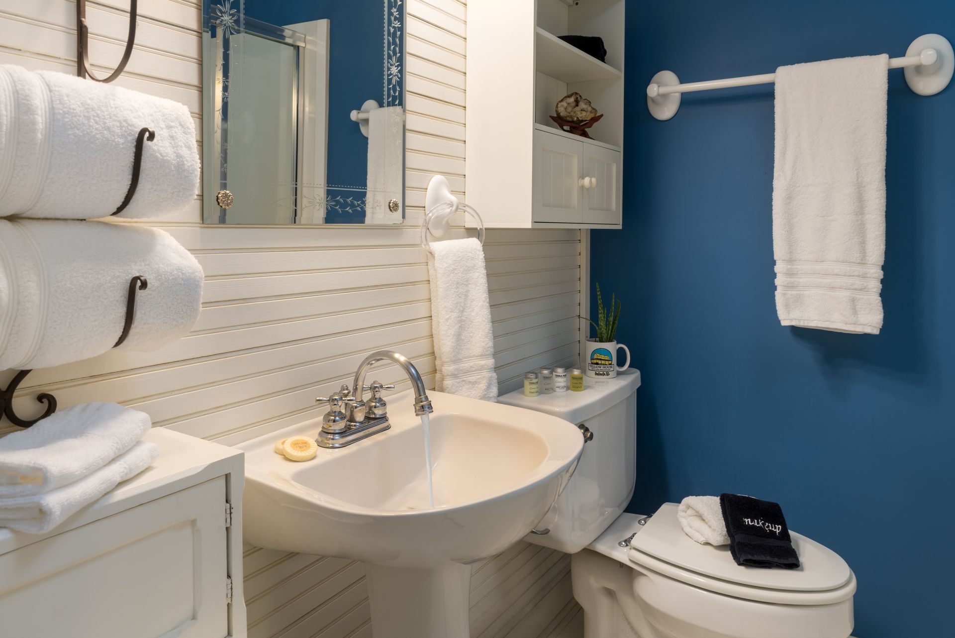 A bathroom with a sink a toilet and a mirror