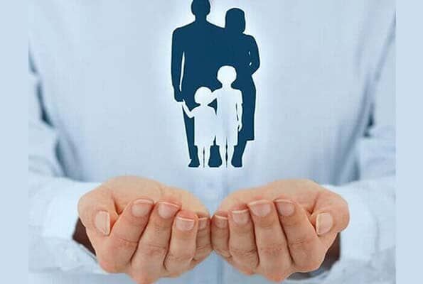 Una persona sostiene en sus manos la silueta de una familia.