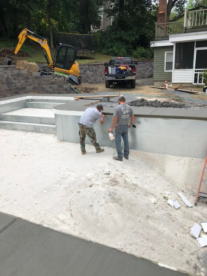 Excavator performing earthmoving near retaining wall
