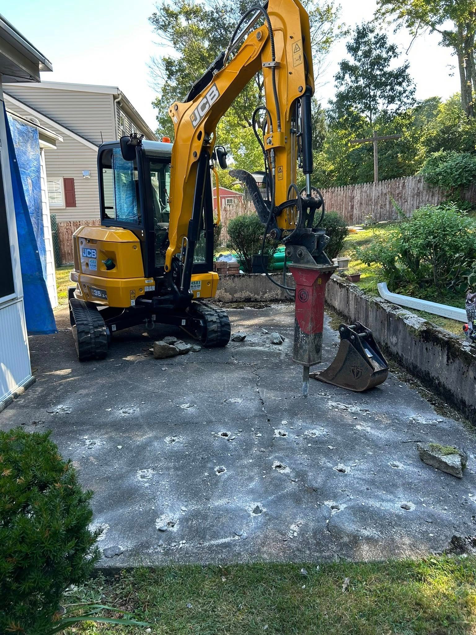 Excavator performing site work at residential property