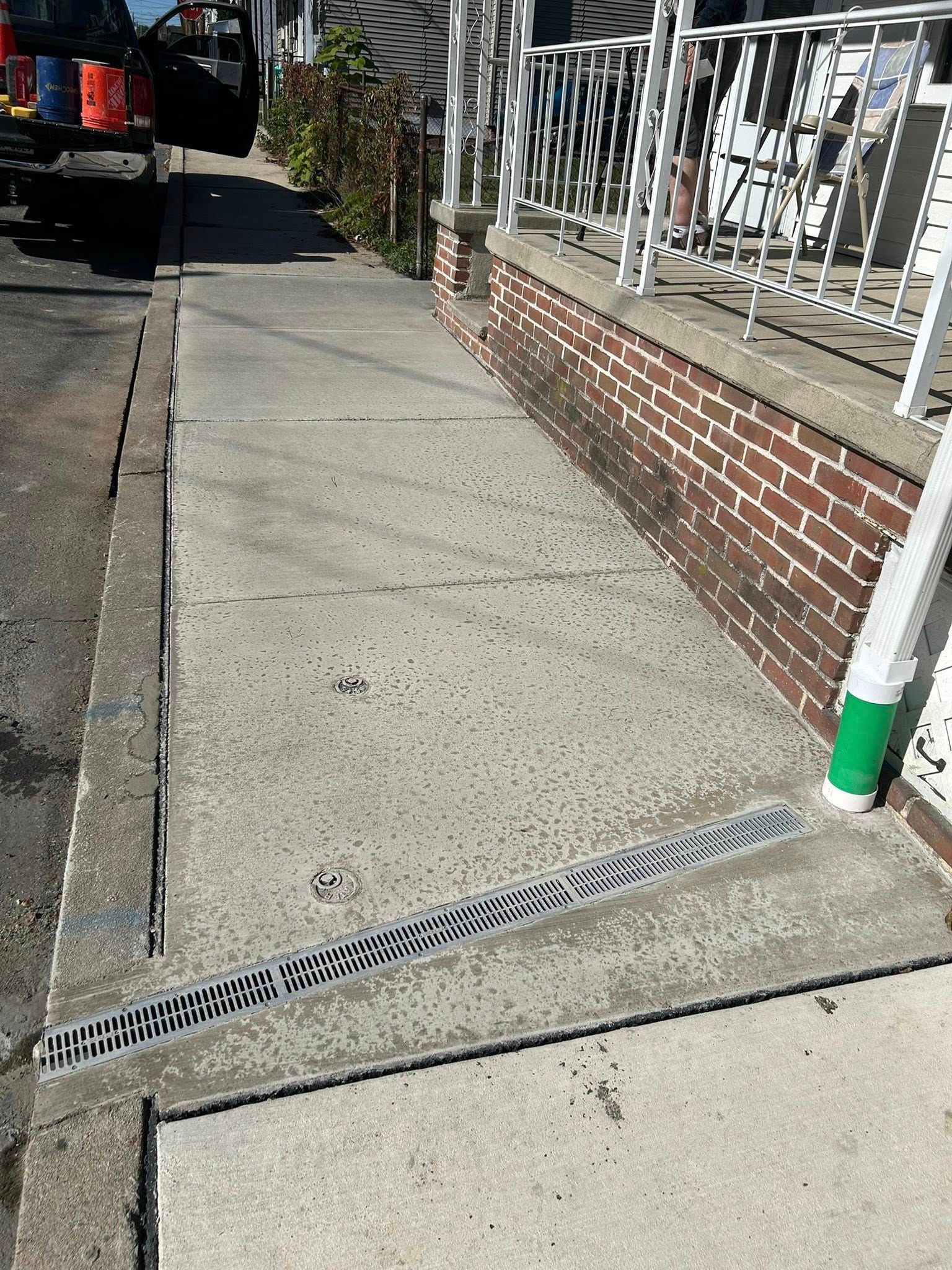 Concrete sidewalk installation along residential foundation