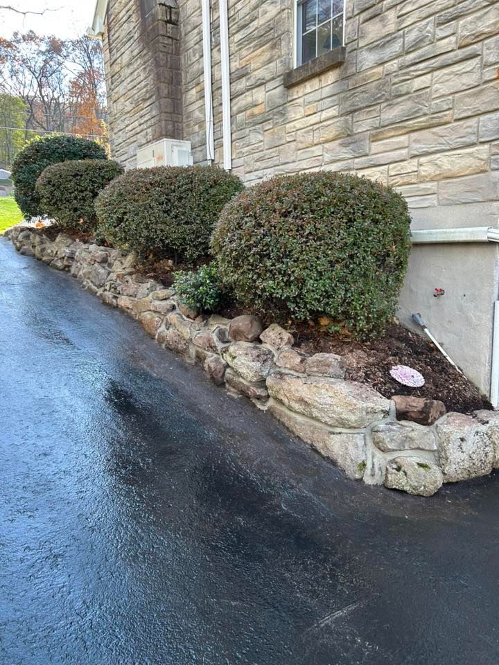 Stone retaining wall installed along residential foundation