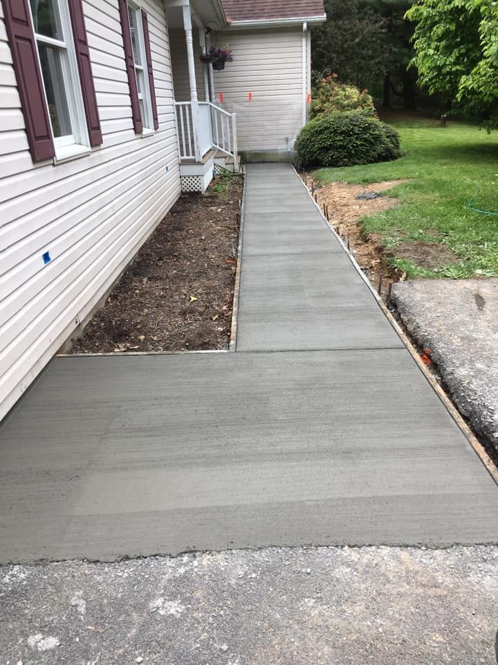Concrete walkway installation along residential home