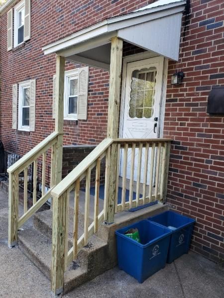 A brick house with a wooden porch and stairs
